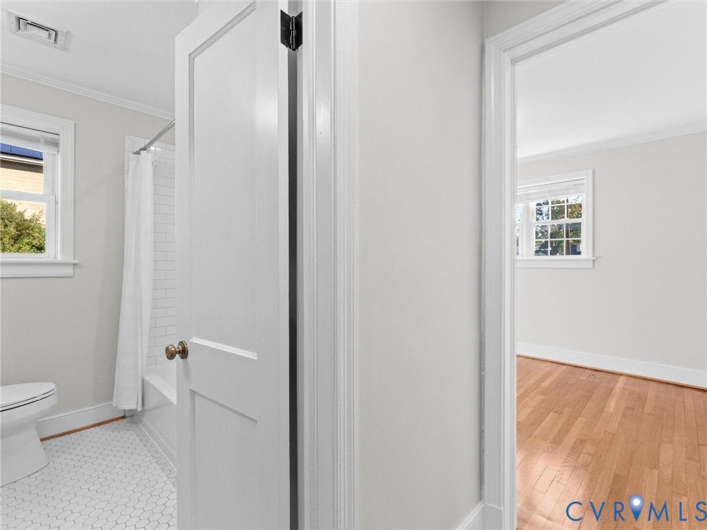 Bathroom featuring white hexagonal tile flooring and subway tile shower surround