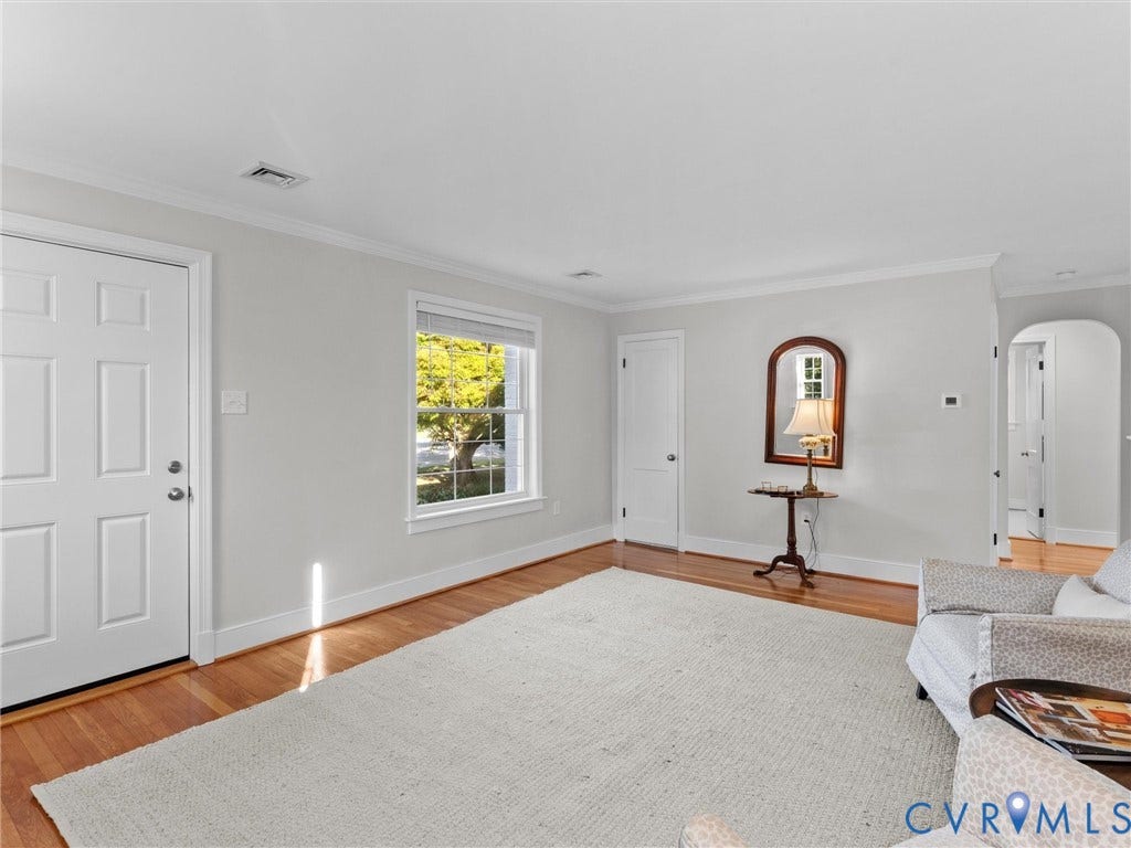 Hardwood flooring, white trim, crown molding, double-pane window, arched doorway