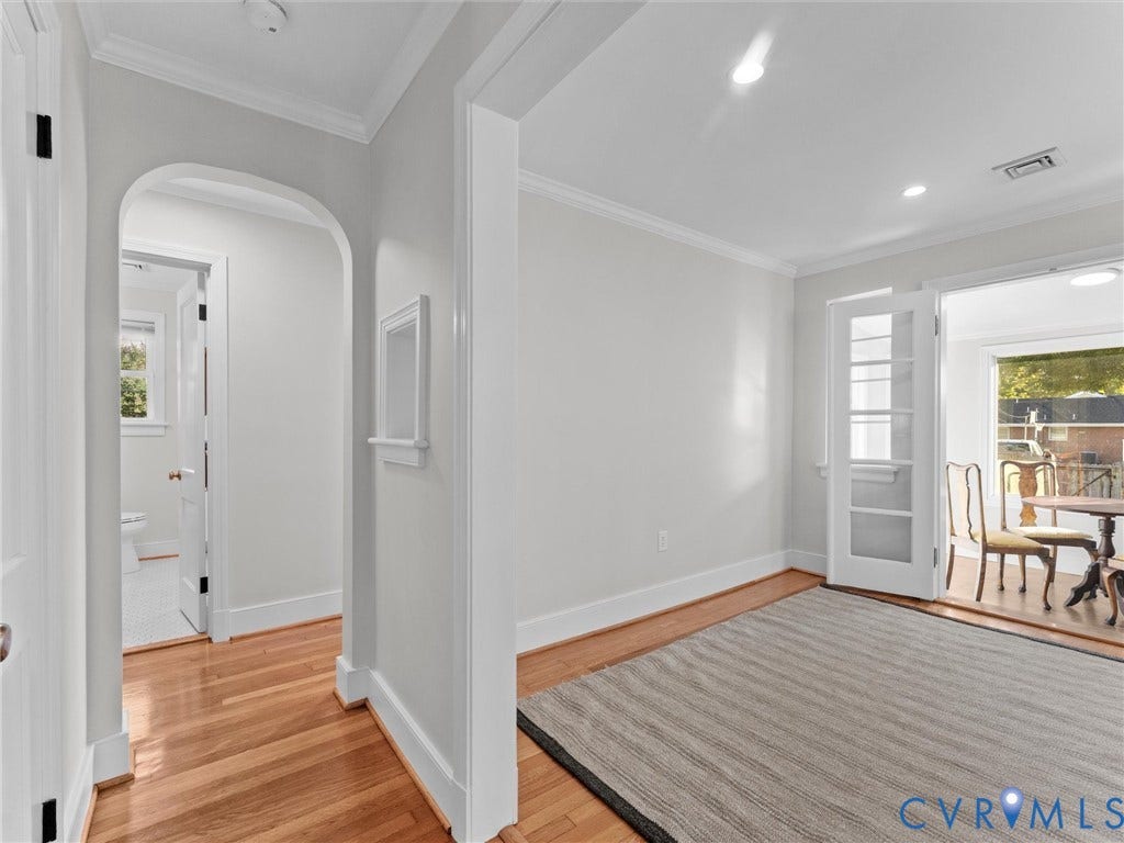 Hardwood flooring, arched doorway, recessed lighting, crown molding, and French doors