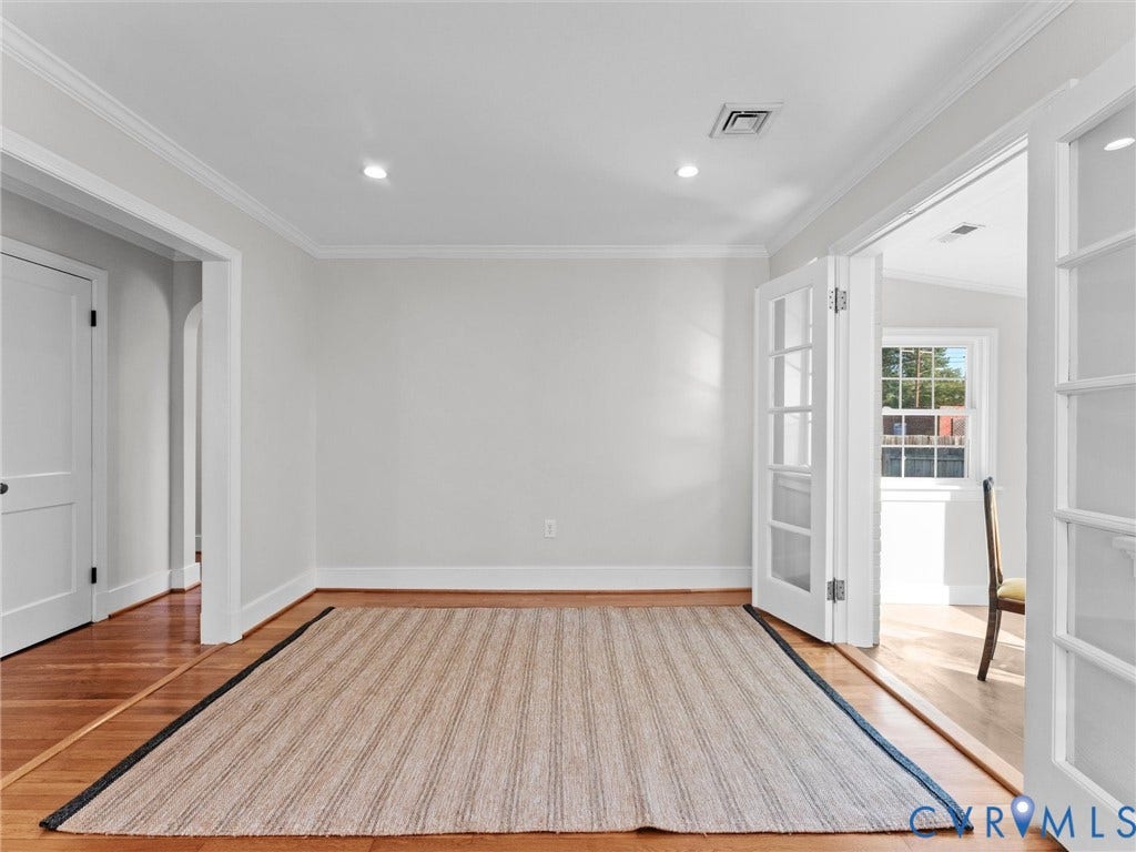 Wood-finish flooring with crown molding, recessed lighting, and French doors