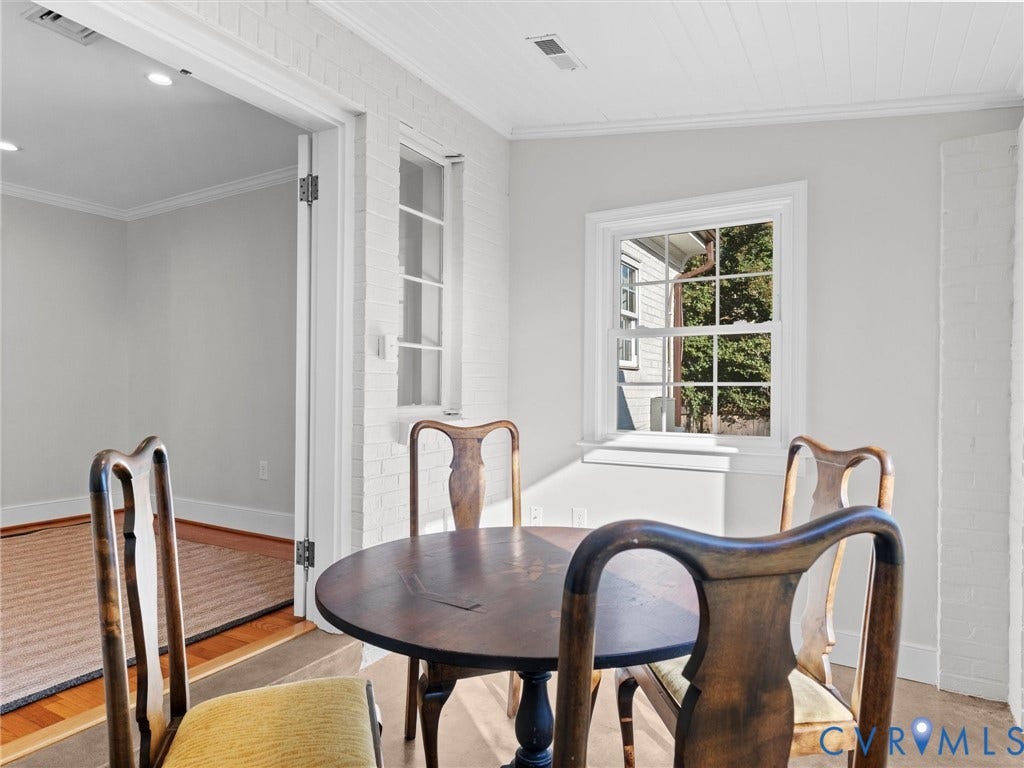 Hardwood flooring, crown molding, double-hung window, white painted brick, and recessed lighting