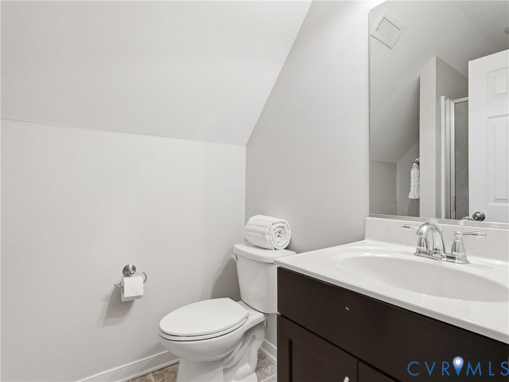 11037 Vogel Court, Bellshire, North Chesterfield, VA 23236 Bathroom featuring a dark wood-finish vanity, white countertop with an integrated oval sink, chrome faucet, and large wall-mounted mirror