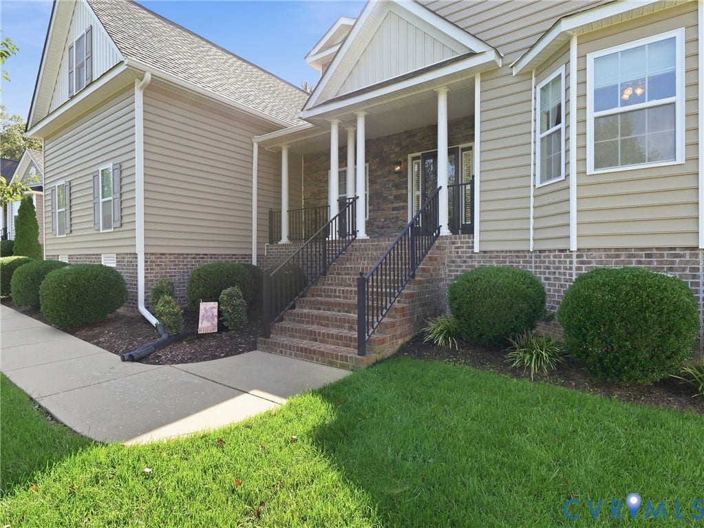 11037 Vogel Court, Bellshire, North Chesterfield, VA 23236 Exterior facade featuring horizontal lap siding, stacked stone veneer, a brick-trimmed foundation, a covered front porch with classical columns, and metal railings