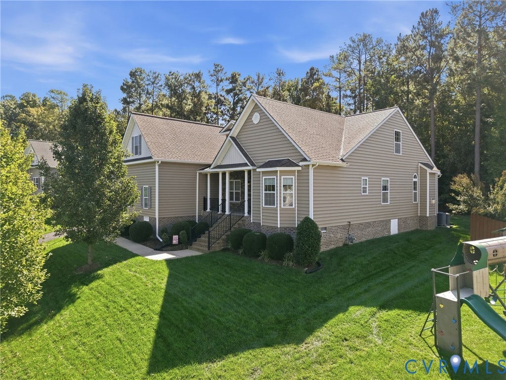 11037 Vogel Court, Bellshire, North Chesterfield, VA 23236 Exterior featuring horizontal siding, brick veneer base, covered front porch with metal railing, and a gabled roofline situated on a landscaped lot