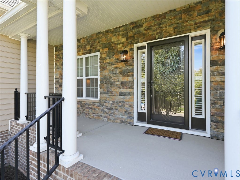 11037 Vogel Court, Bellshire, North Chesterfield, VA 23236 Covered front porch featuring stacked stone veneer, white columns, and a decorative glass-panel entry door with matching sidelights