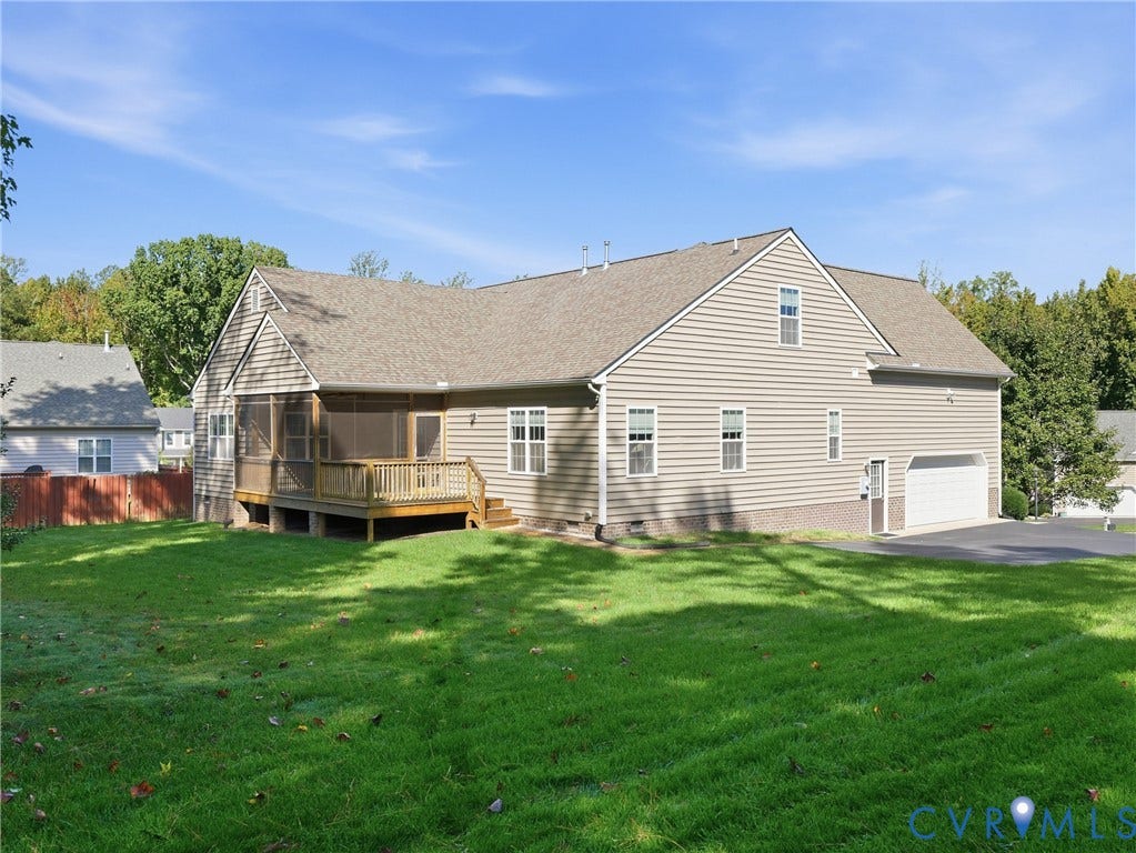 11037 Vogel Court, Bellshire, North Chesterfield, VA 23236 Rear exterior featuring horizontal lap siding, brick foundation detailing, attached two-car garage, screened porch with wood decking, and a spacious lawn
