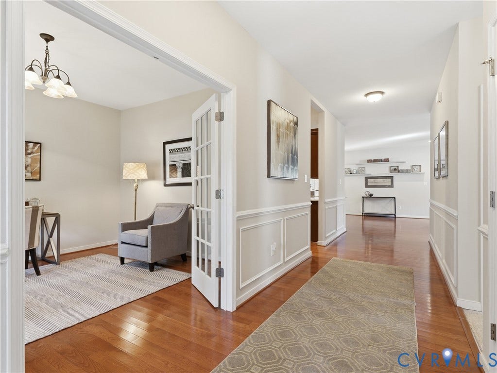 11037 Vogel Court, Bellshire, North Chesterfield, VA 23236 Interior hallway and room featuring wood-finish flooring, white paneled wainscoting, French doors with glass panes, and an attached multi-light chandelier