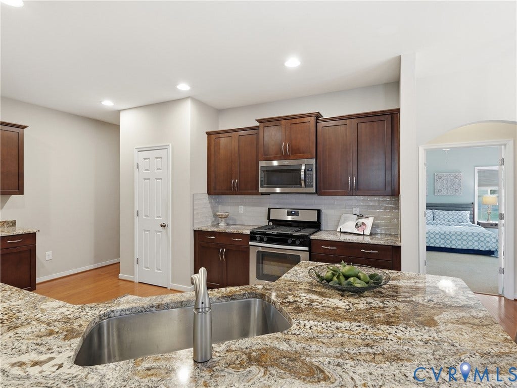 11037 Vogel Court, Bellshire, North Chesterfield, VA 23236 Kitchen featuring wood cabinetry, stone countertops, stainless steel appliance suite, tiled backsplash, and an undermount sink