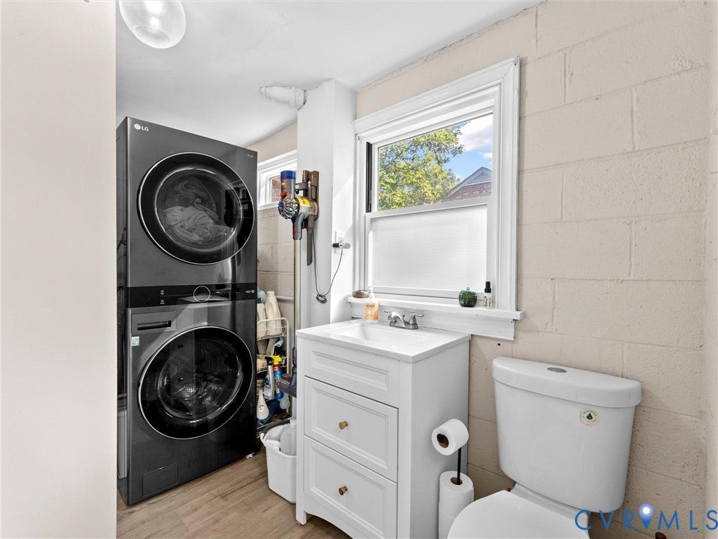 8341 Charlise Road, Stratford Hills, Midlothian, VA 23235 White vanity with a rectangular sink, dual-stack front-load washer and dryer, wood-finish flooring, and painted masonry walls