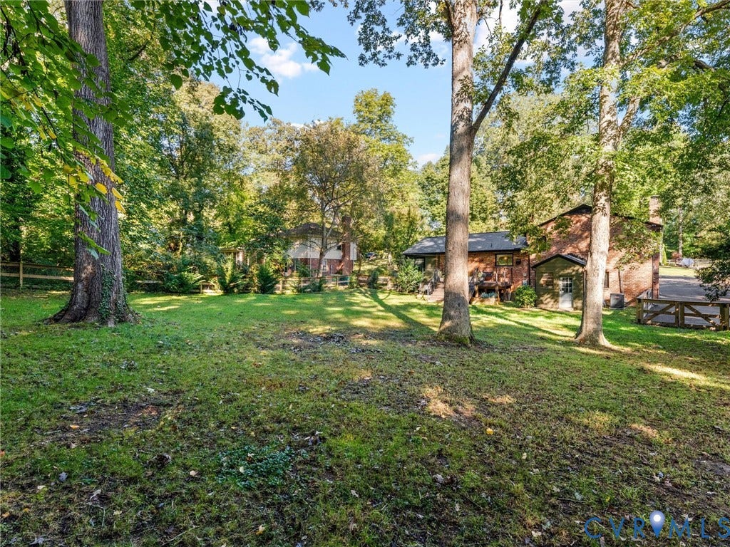 8341 Charlise Road, Stratford Hills, Midlothian, VA 23235 Expansive backyard featuring mature trees, a manicured lawn, and wood-style fencing