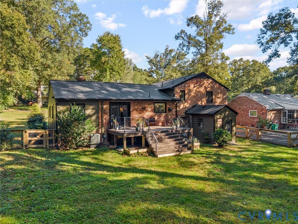8341 Charlise Road, Stratford Hills, Midlothian, VA 23235 Brick exterior featuring an elevated wood deck with metal railings, a ground-level outbuilding, and wood-panel perimeter fencing surrounded by mature trees