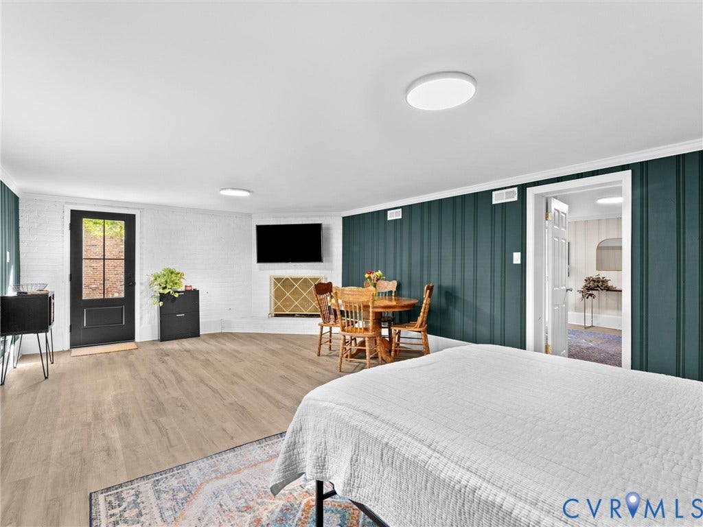 8341 Charlise Road, Stratford Hills, Midlothian, VA 23235 Wood-finish flooring, dark-toned vertical paneled wall, white painted brick, and exterior access door with glass pane