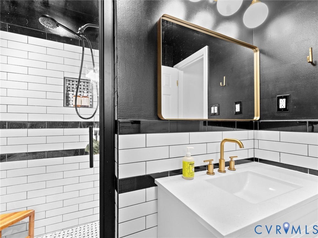 8341 Charlise Road, Stratford Hills, Midlothian, VA 23235 Modern vanity featuring a white countertop with an integrated basin, gold-finish widespread faucet, and brass-framed rectangular mirror