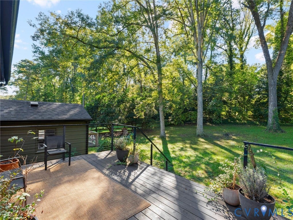 8341 Charlise Road, Stratford Hills, Midlothian, VA 23235 Elevated wood-plank deck featuring a black metal railing and expansive rear yard with mature trees