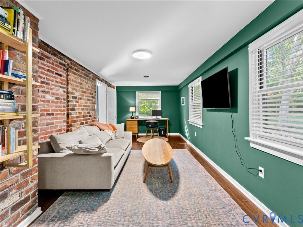 8341 Charlise Road, Stratford Hills, Midlothian, VA 23235 Exposed brick wall, wood-finish flooring, and multiple windows with horizontal blinds