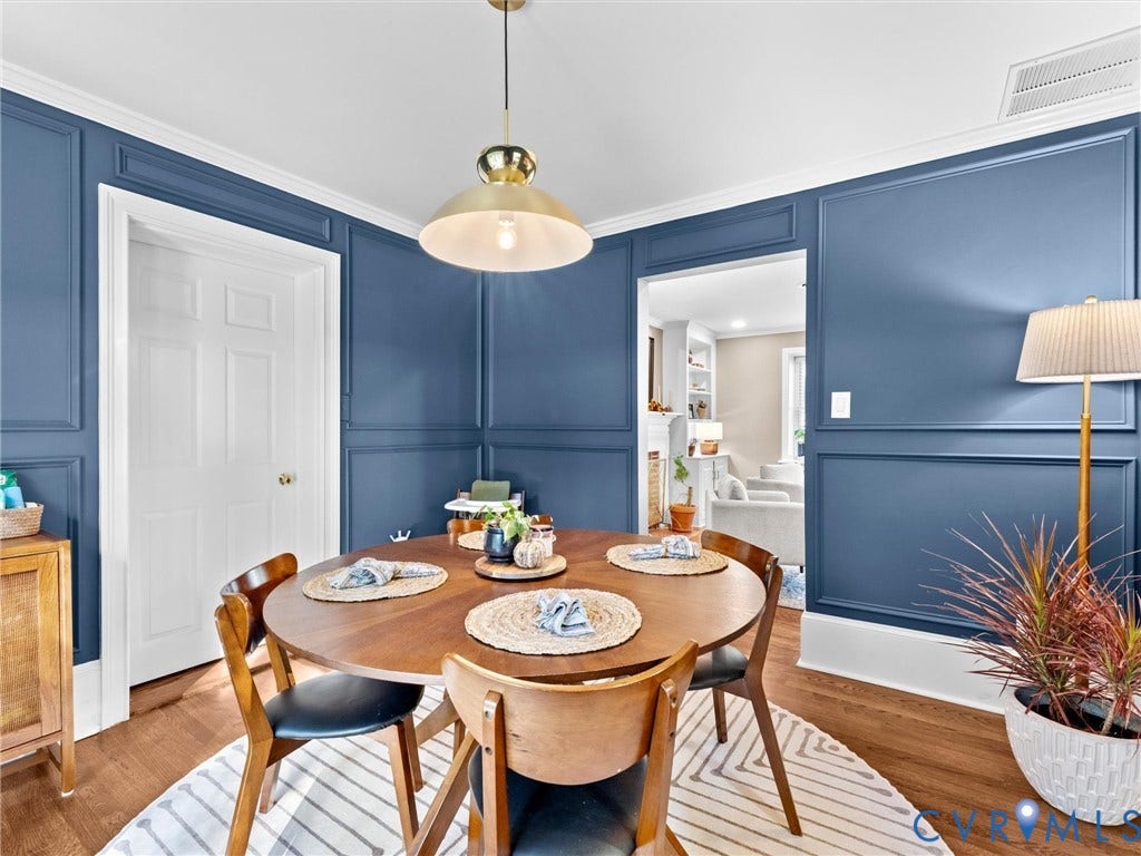 8341 Charlise Road, Stratford Hills, Midlothian, VA 23235 Dining space featuring deep blue wall paneling, crown molding, wood-finish flooring, and a brass-tone pendant light fixture