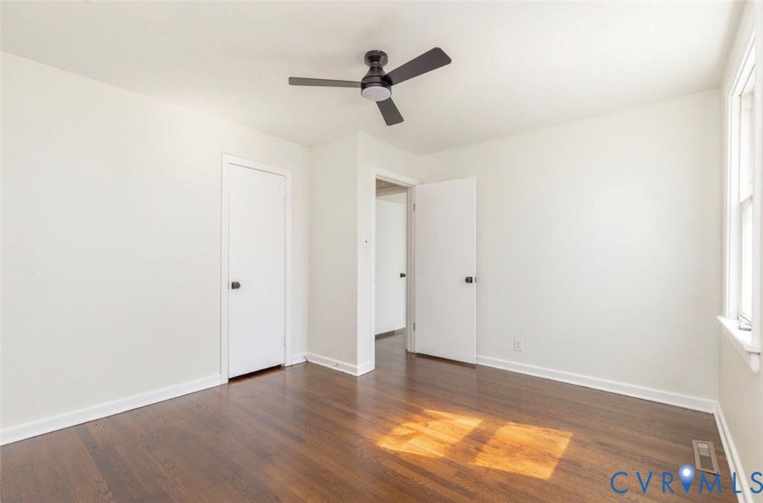 2211 Apollo Road, Fairfield, VA 23223 Wood-finish flooring, white walls, white trim, white doors with dark hardware, and a ceiling fan with dark blades