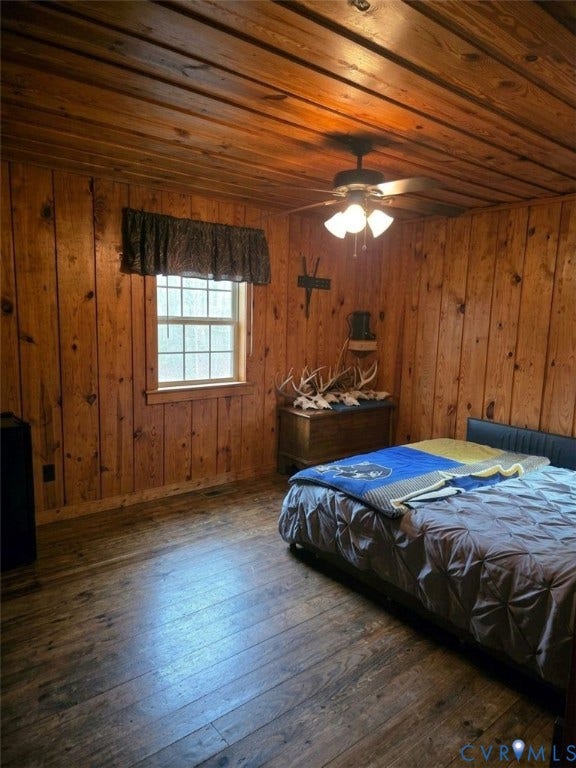 Wood-paneled walls and ceiling, wood-finish flooring, and a ceiling fan with integrated lighting