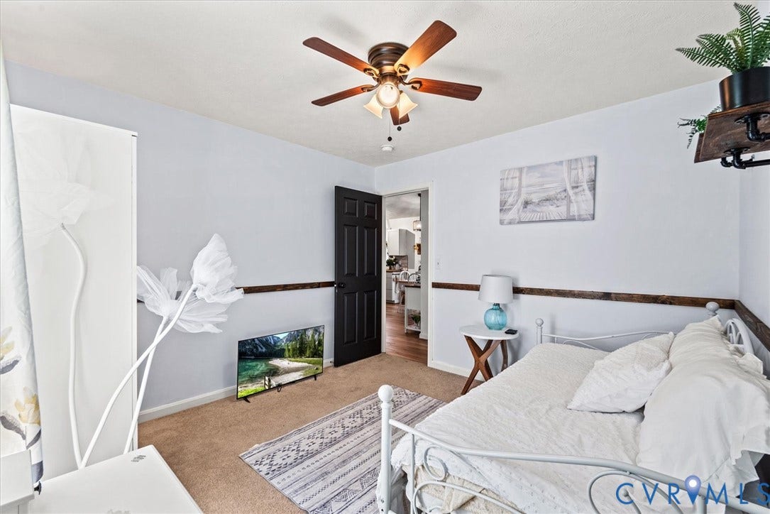 2421 Pittston Road, Ruffin's Pond, Fredericksburg, VA 22408 Ceiling fan with light fixture, light gray wall paint, wood-finish wall trim, dark paneled interior door, and carpet flooring