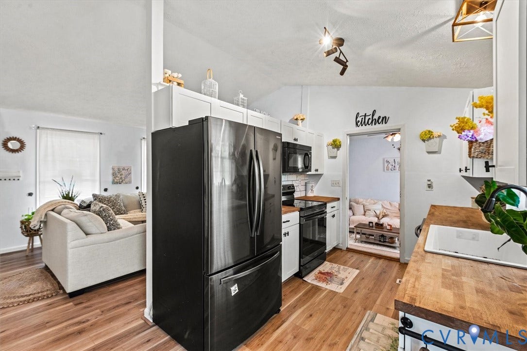 2421 Pittston Road, Ruffin's Pond, Fredericksburg, VA 22408 Wood-finish flooring, white cabinetry, black appliances, wood countertops, and a white sink