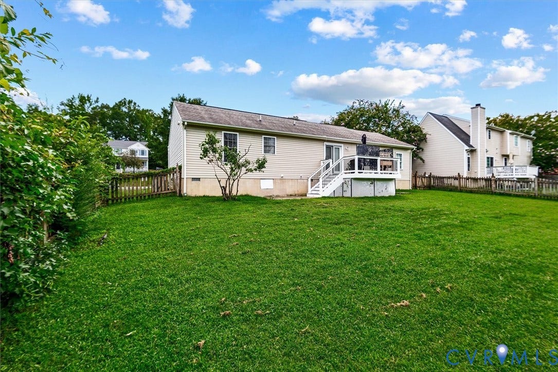 2421 Pittston Road, Ruffin's Pond, Fredericksburg, VA 22408 Expansive green lawn with a white wooden deck and stairway, complemented by a picket fence