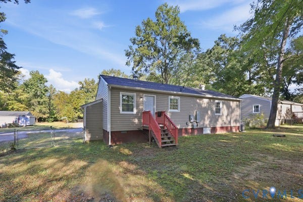 4647 Twelveoaks Road, Midlothian, VA 23112 Exterior featuring horizontal vinyl siding, a rear wood staircase with handrails, and a mature tree-lined lot with chain-link fencing