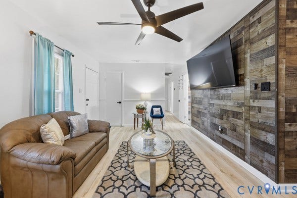 4647 Twelveoaks Road, Midlothian, VA 23112 Accent wall featuring reclaimed wood paneling, light wood-finish flooring, and a modern ceiling fan with integrated lighting