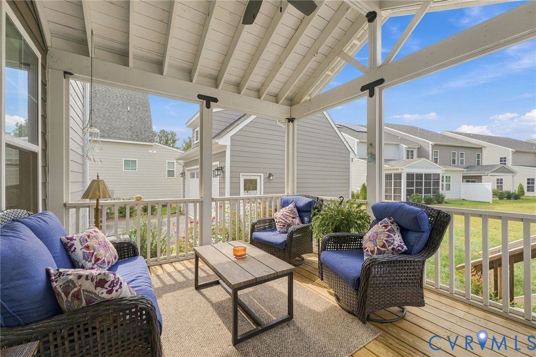 Screened porch with wood flooring, vaulted ceiling, and white railing