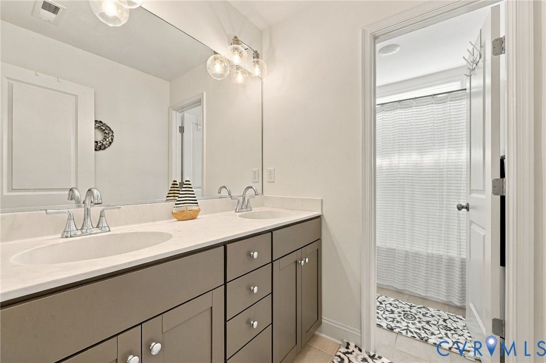 Double vanity with undermount sinks, chrome faucets, and a light-toned countertop