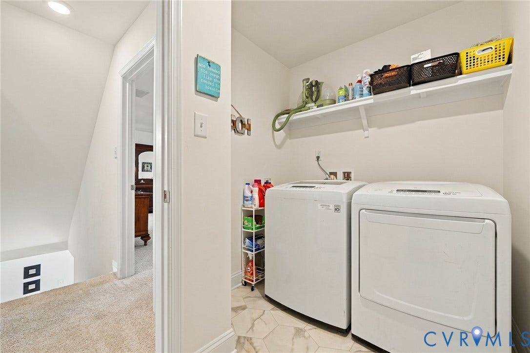 Dedicated laundry area featuring a built-in shelf, white appliances, and hexagonal floor tiling