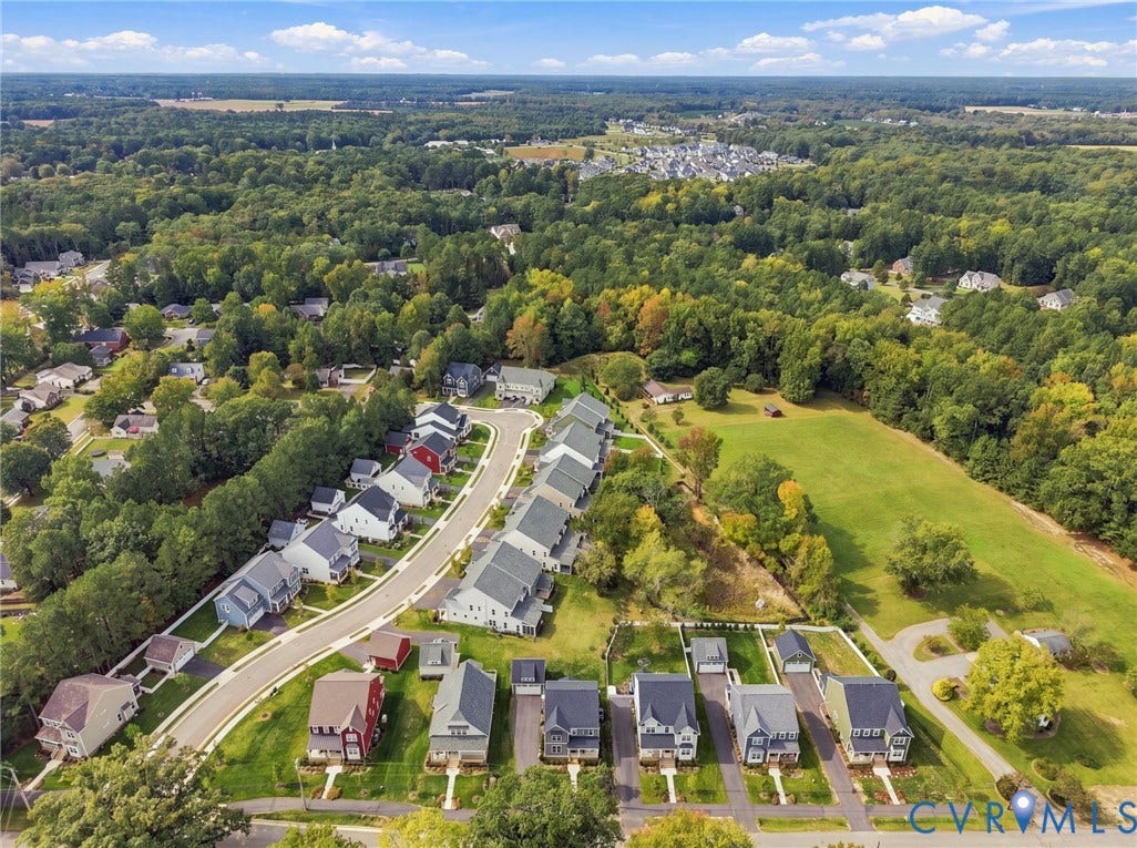 Residential community with varied architectural styles, individual driveways, and surrounding green spaces