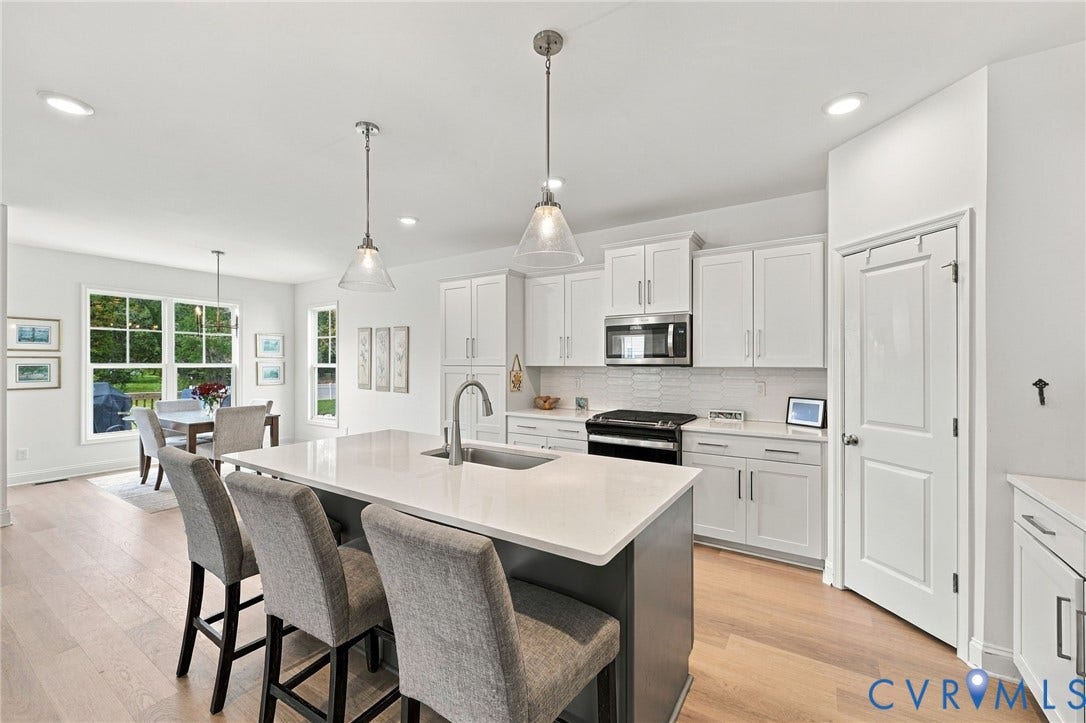 Open-concept kitchen with a central island, recessed lighting, and wood-finish flooring