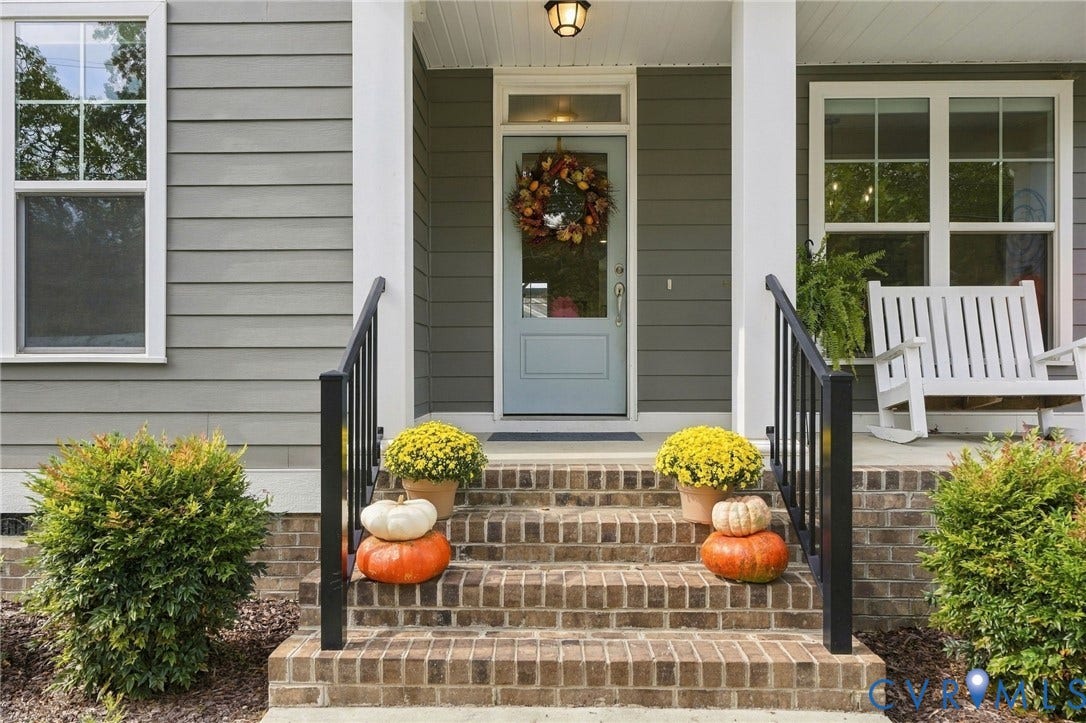 Brick stairs with black handrails leading to a light blue entry door