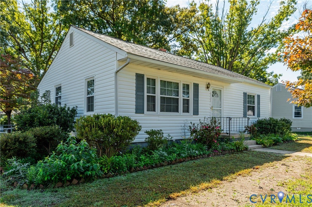1701 Kingswood Street, Richmond, VA 23224 Exterior featuring white horizontal siding, dark shutters, an asphalt shingle roof, and a front entrance with a metal security door and iron railing