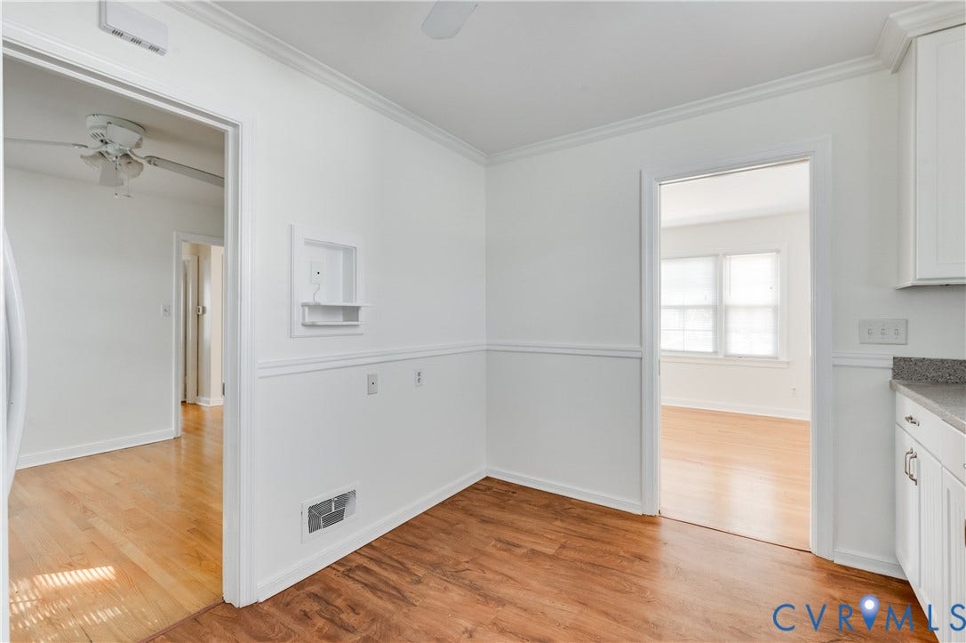 1701 Kingswood Street, Richmond, VA 23224 Interior space featuring wood-finish flooring, wainscoting, crown molding, and white shaker-style cabinetry with stone-surface countertops