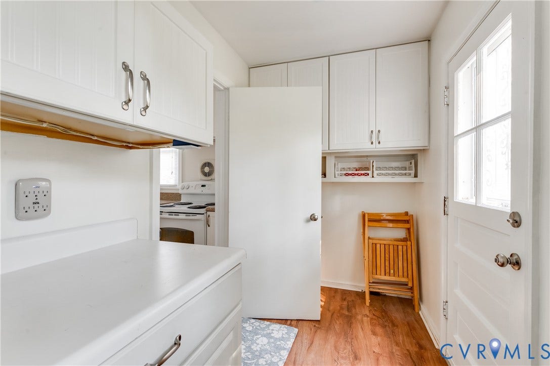 1701 Kingswood Street, Richmond, VA 23224 White cabinetry with metallic hardware, wood-finish flooring, and a multi-pane glass door