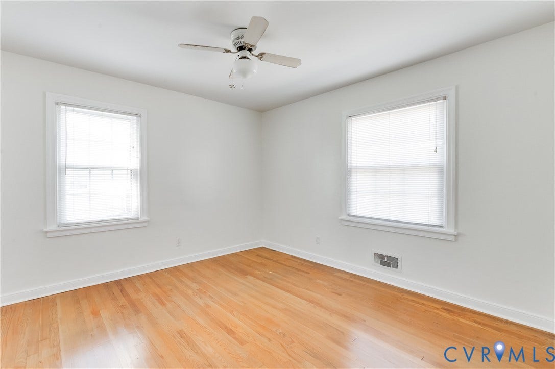 1701 Kingswood Street, Richmond, VA 23224 Interior space featuring wood-finish flooring, two multi-pane windows with trim, and a ceiling-mounted fan with integrated light fixture