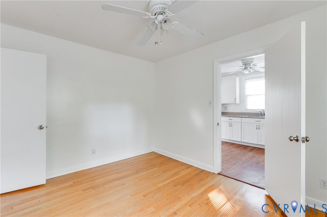 1701 Kingswood Street, Richmond, VA 23224 Neutral-toned room featuring wood-finish flooring, a white ceiling fan, and solid-core interior doors