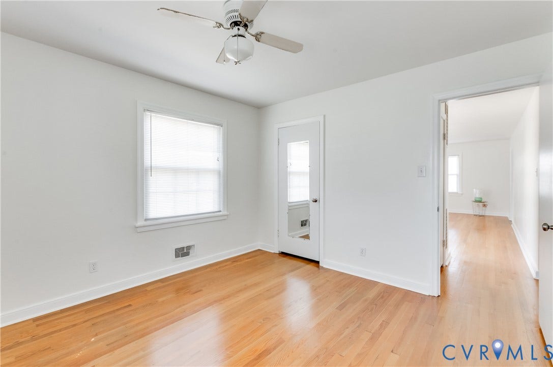 1701 Kingswood Street, Richmond, VA 23224 Wood-finish flooring, white walls, ceiling fan with light fixture, and door with an integrated full-length mirror