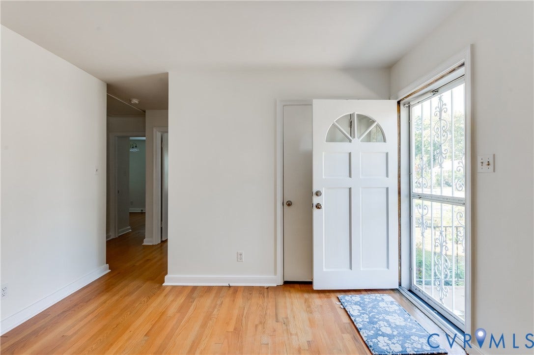 1701 Kingswood Street, Richmond, VA 23224 Interior space featuring wood-finish flooring, a white paneled front door with a semi-circular transom window, and a metal security screen door