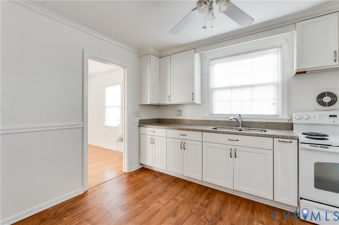1701 Kingswood Street, Richmond, VA 23224 Kitchen featuring white shaker-style cabinetry, solid-surface countertops, wood-finish flooring, a double-basin stainless steel sink, and a ceiling fan