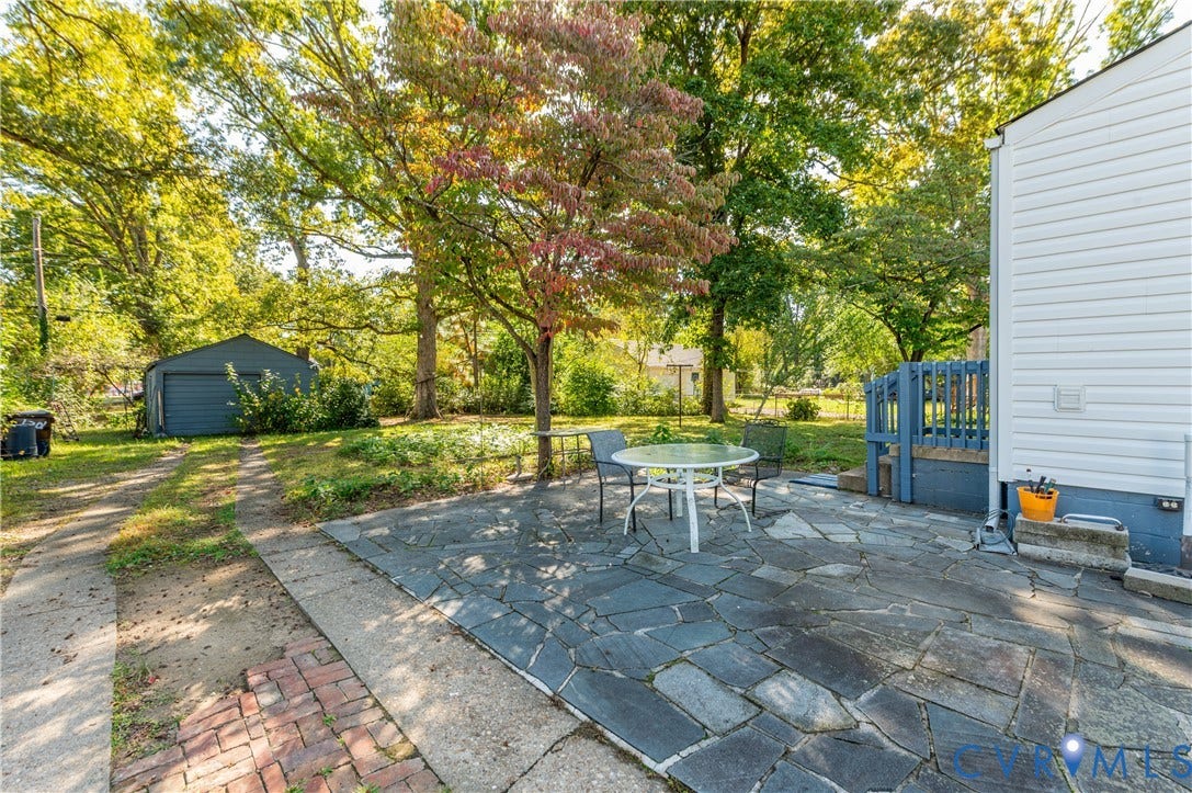 1701 Kingswood Street, Richmond, VA 23224 Flagstone patio, detached storage structure, and horizontal siding exterior
