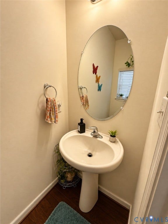 10507 Benoni Trail, Glen Allen, VA 23059 Pedestal sink with chrome faucet, oval mirror, and wood-finish flooring