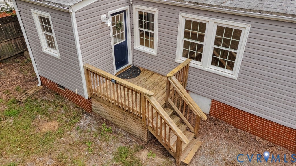 4130 Sprenkle Lane, Wistar Heights, Henrico, VA 23228 Wood deck with railing, gray vinyl siding, white-framed windows with grilles, brick foundation, and a dark blue exterior door