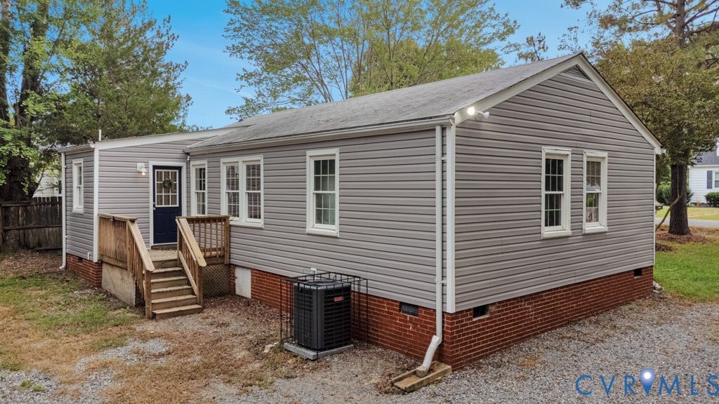 4130 Sprenkle Lane, Wistar Heights, Henrico, VA 23228 Grey vinyl siding exterior with a dark blue entry door, an exterior wooden deck and stairs, and a brick foundation