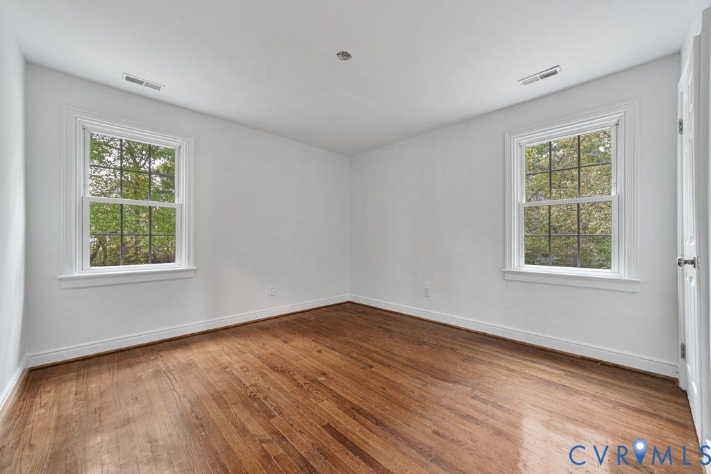 4130 Sprenkle Lane, Wistar Heights, Henrico, VA 23228 Hardwood flooring, two large windows with white trim, recessed lighting, and a white paneled door with a brushed nickel knob