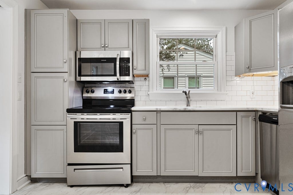 4130 Sprenkle Lane, Wistar Heights, Henrico, VA 23228 Stainless steel appliances, light gray shaker-style cabinetry, subway tile backsplash, solid surface countertops, and wood-finish flooring