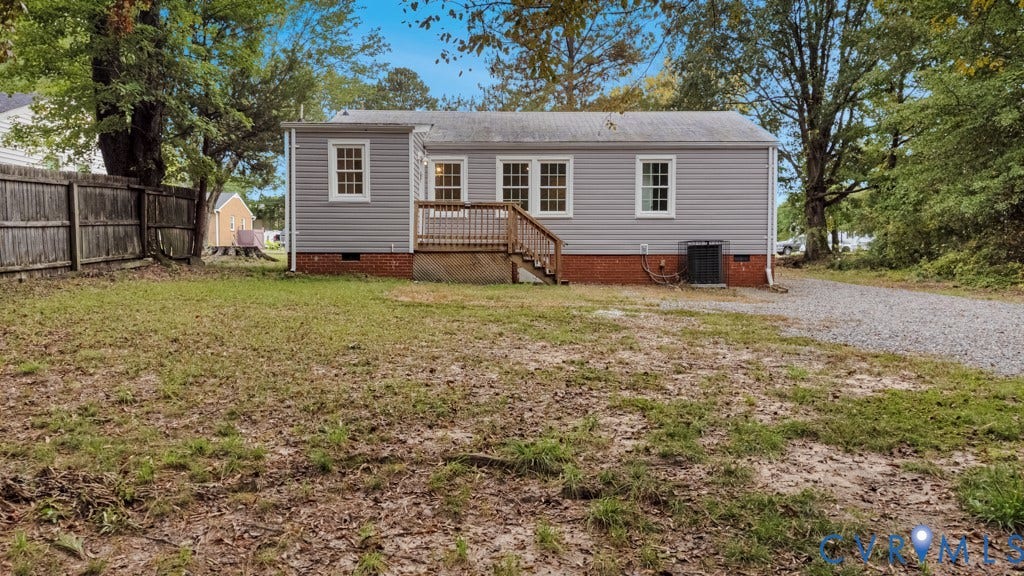 4130 Sprenkle Lane, Wistar Heights, Henrico, VA 23228 Rear exterior with light gray siding, brick foundation, a wood deck with railings, and a gravel driveway