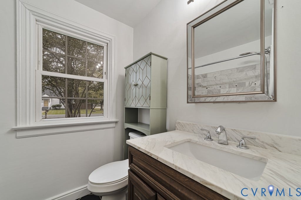 4130 Sprenkle Lane, Wistar Heights, Henrico, VA 23228 White framed window, ornate mirror, vanity with stone countertop, drop-in sink, and chrome fixtures
