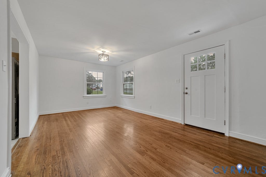 4130 Sprenkle Lane, Wistar Heights, Henrico, VA 23228 Wood-finish flooring, white walls, two double-hung windows, frosted glass door, and a decorative flush-mount light fixture